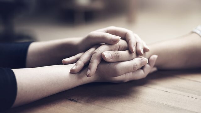 Holding hands at wood table - Small